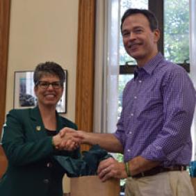 Dr. Charles Heise shakes hands with DelVal President Dr. Maria Gallo.