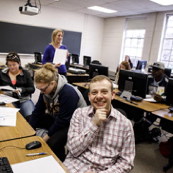 Smiling student in a busy classroom.