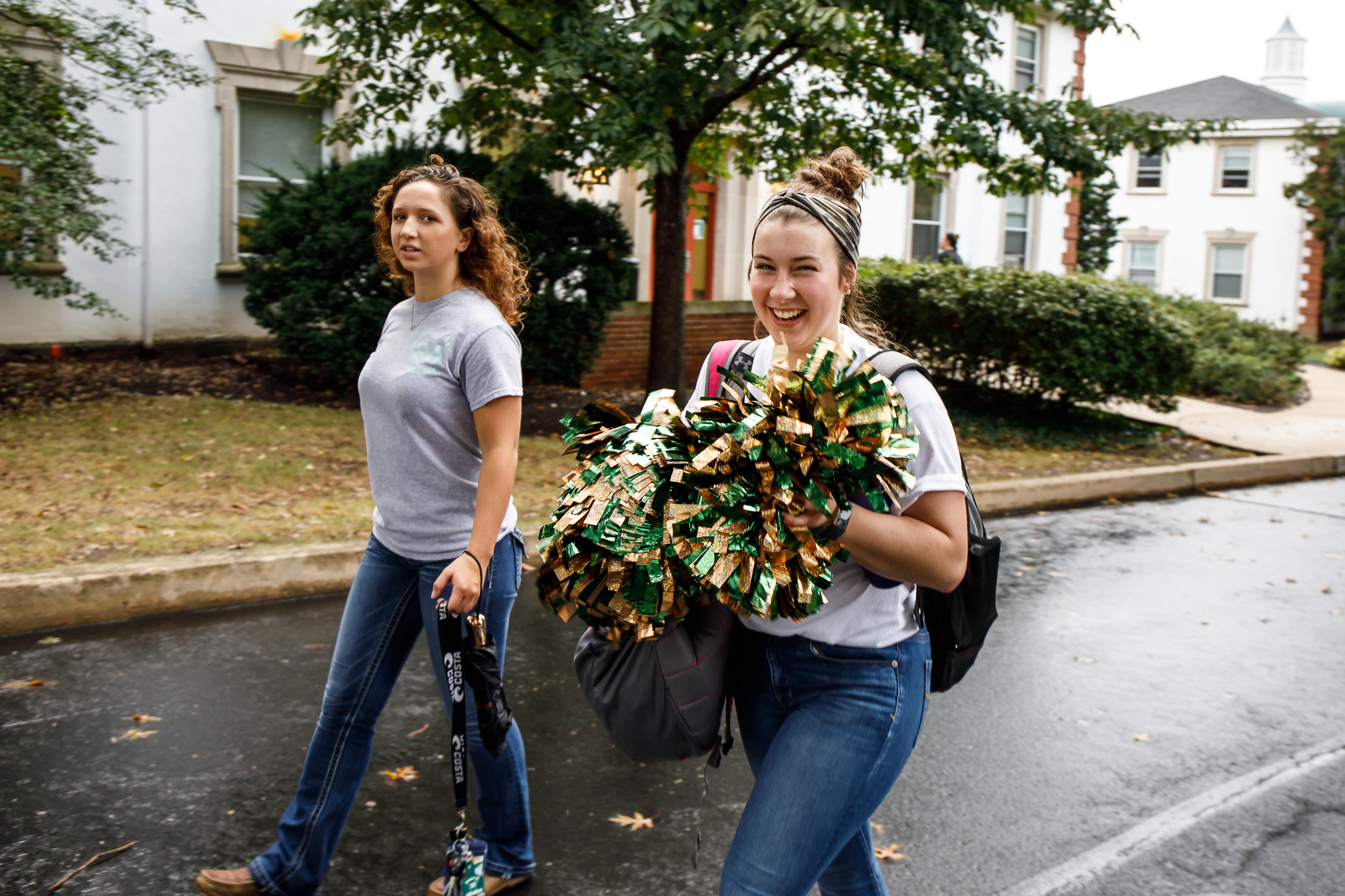 Students walking on DelVal's campus with pompoms