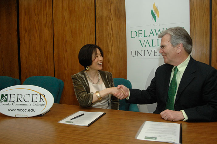 Mercer County Community College's president shakes hands with DelVal's president at the signing ceremony.