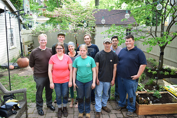 The group of students and staff with Corinne in the new garden