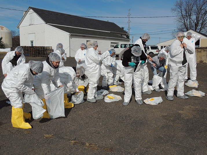 A group of students puts on personal protection equipment during the mock outbreak.