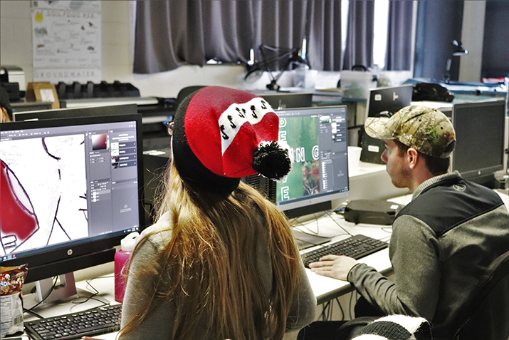 Students are working in the Design Studio to create signage for the display.