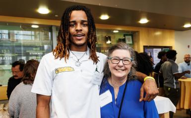 A student and Joan Hock, former director of financial aid, pose for a photo.