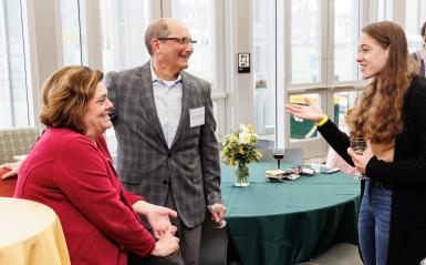 A student is speaking to two donors a the scholarship reception.