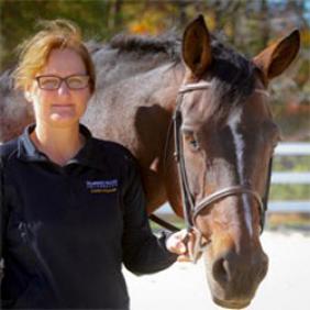 Stephanie Barberra standing outside with a horse.