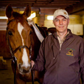 Dr. Angelo Telatin stands next to a horse.