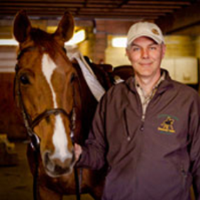 Dr. Angelo Telatin stands next to a horse. 