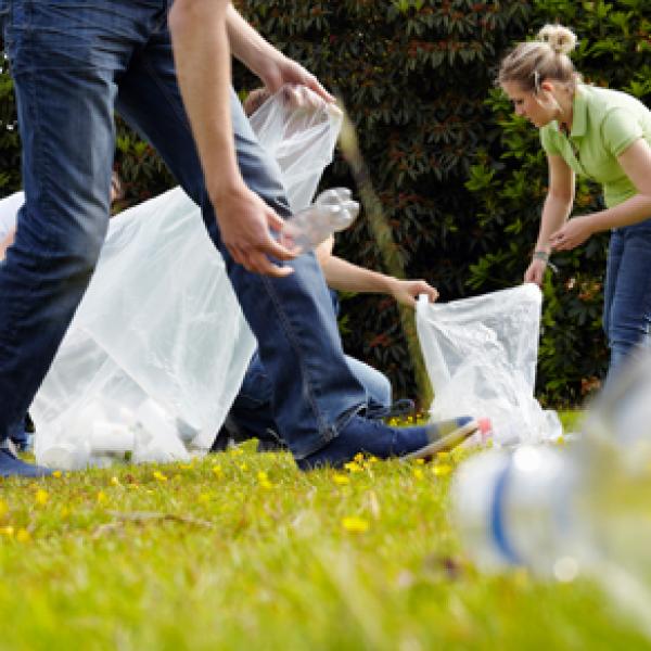 Group of students outside cleaning up litter