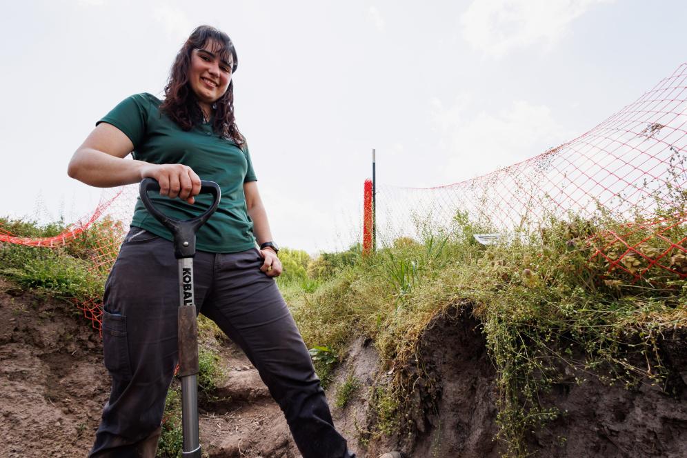 Jaclyn Fiola digging with a shovel in a soil pit.