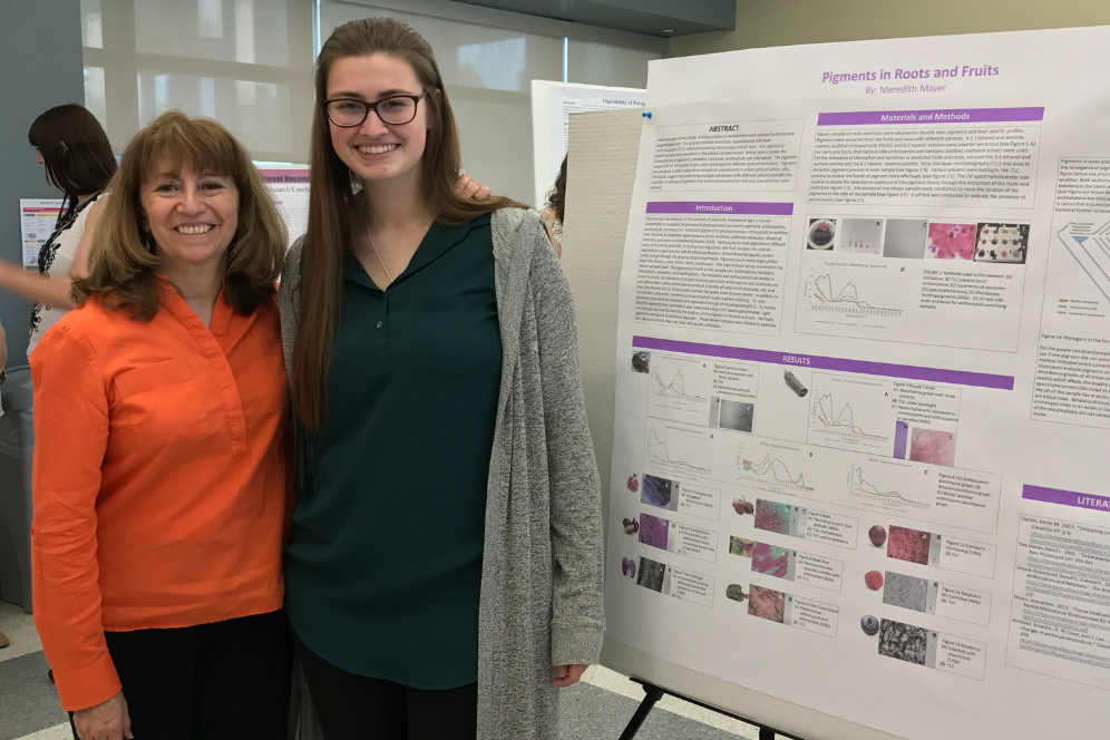 Meredith Mayer, a biology student, is with Elizabeth Skendzic, a biology professor, beside a presentation poster.