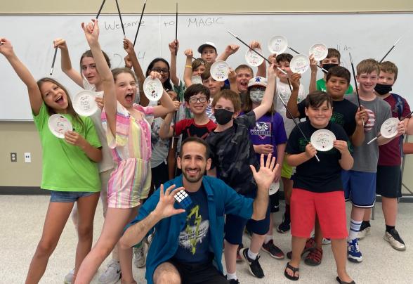 Students age 5 to 14 pose for a group photo with an instructor. 