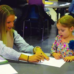 female student drawing with child