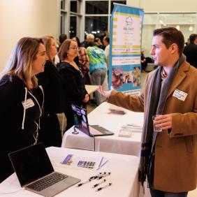 Three people are networking before the spark bowl event in the LSB Atrium.