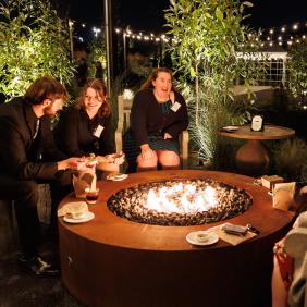 Students are sitting by a bonfire at Terrain Events Venue on campus