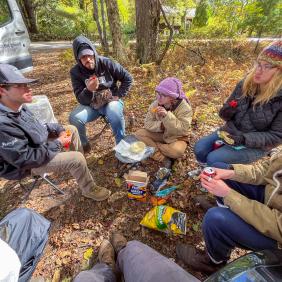 Students are in a soil pit, analyzing soil samples.
