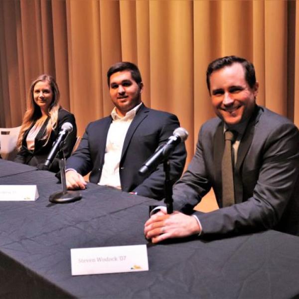 Panelists sit at a table