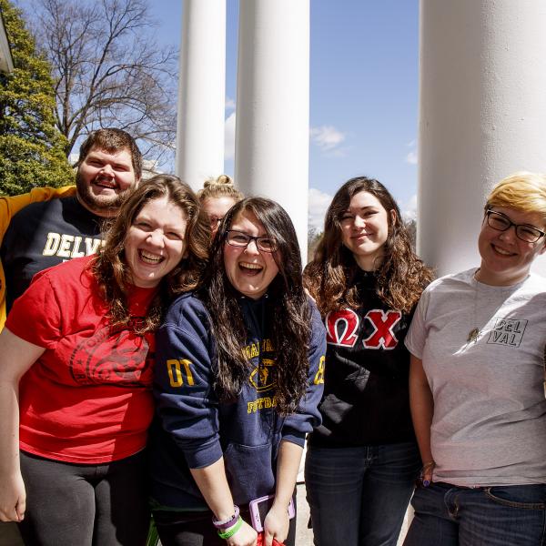 A large group of smiling students on the steps of Work Hall.