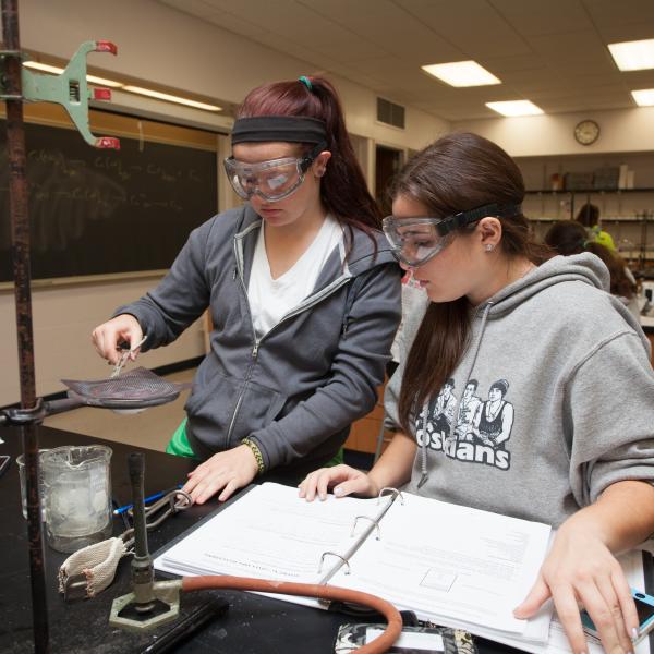 Two lab partered students using scientific equipment.
