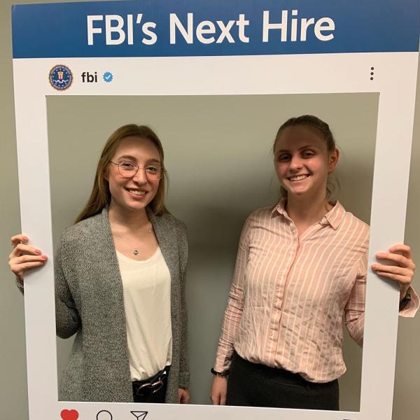 Two female students in a frame saying "FBI's next hire" at the top. 