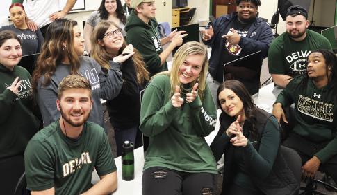 A large group of students sits together at a club meeting.
