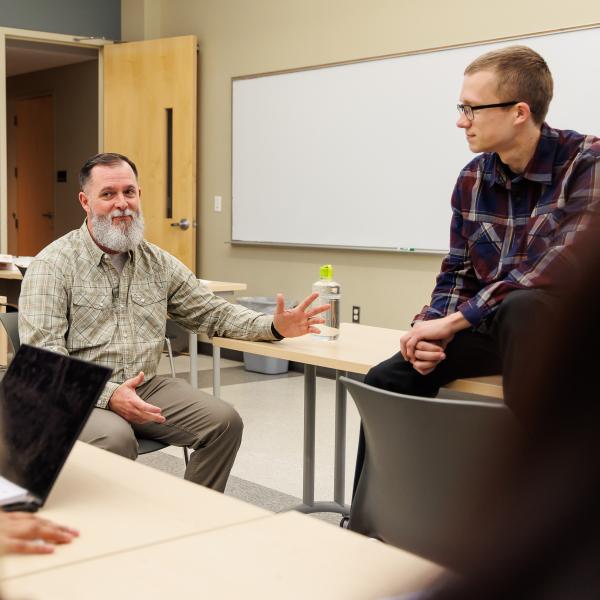 A student and a teacher are speaking one on one. 